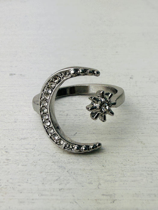 silver-tone ring featuring a crescent moon and star with sparkling crystals.