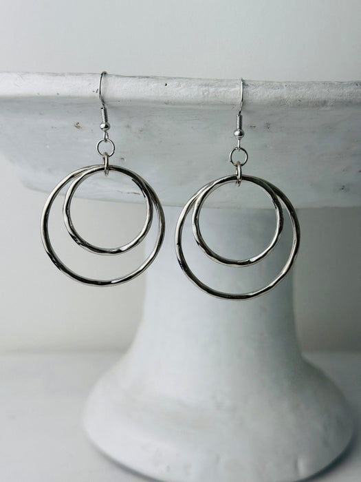 close-up of silver double hoop dangle earrings