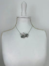 Necklace with a floral pendant on a mannequin bust against a white background