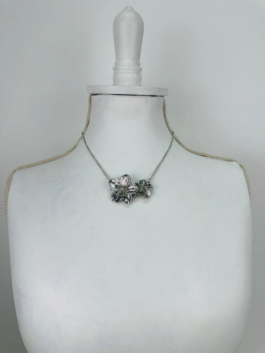 Necklace with a floral pendant on a mannequin bust against a white background
