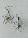 close-up of silver flower-shaped earrings 