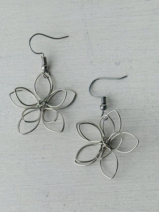 close-up of silver flower-shaped earrings 