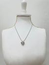 Necklace with a heart-shaped pendant on a mannequin bust against a plain background