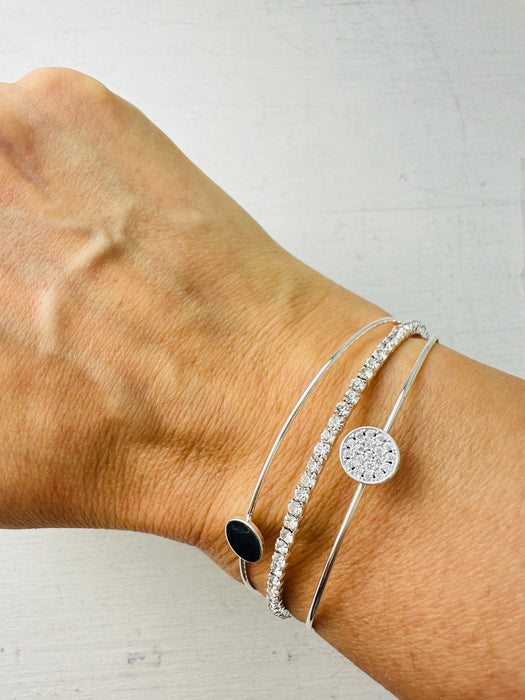 Silver bracelet with a black stone on a wrist against a white background