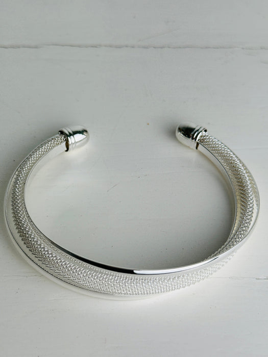 Silver bracelet on a light gray background