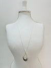 Long silver-tone necklace with a teardrop pendant on a mannequin