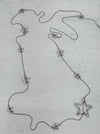 Silver star-shaped necklace on a textured surface
