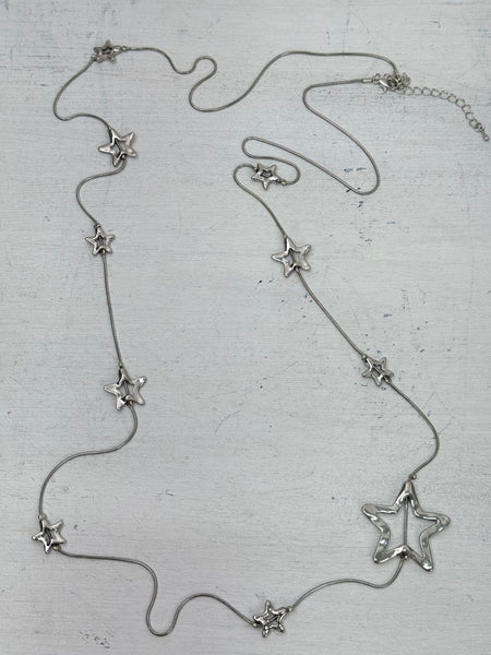 Silver star-shaped necklace on a textured surface