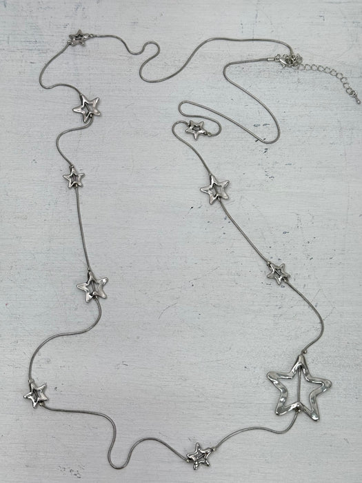 Silver star-shaped necklace on a textured surface