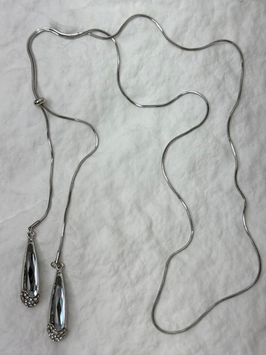 Silver necklace with two pendant ends on a light gray background