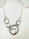 close-up of silver textured circle link necklace with abstract overlapping rings