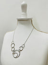 side angle of silver textured circle link necklace with abstract overlapping rings