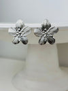 close-up of silver-tone floral earrings 