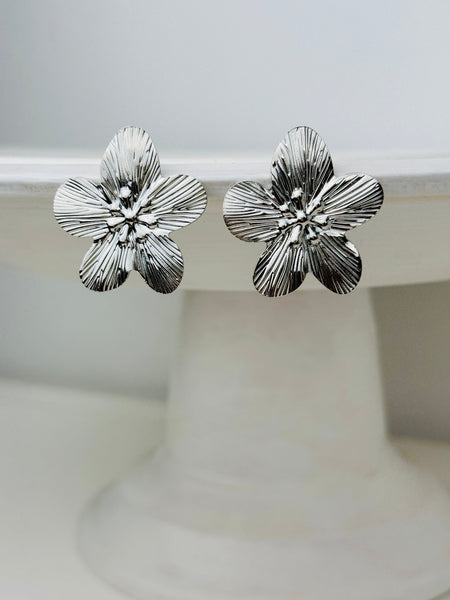 close-up of silver-tone floral earrings 