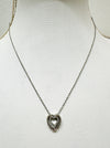 A silver necklace with a double heart pendant featuring a crystal detail, displayed on a mannequin.