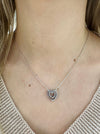 Heart-shaped necklace on a person wearing a light-colored top