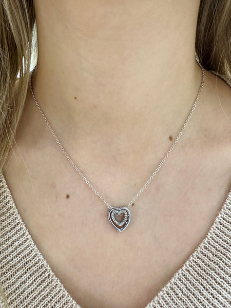 Heart-shaped necklace on a person wearing a light-colored top