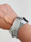 Silver layered cuff bracelet with overlapping metal bands and polished finish dispayed on a model