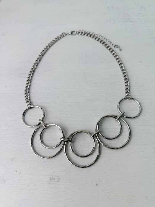 close-up of modern silver tone necklace with layered open circles