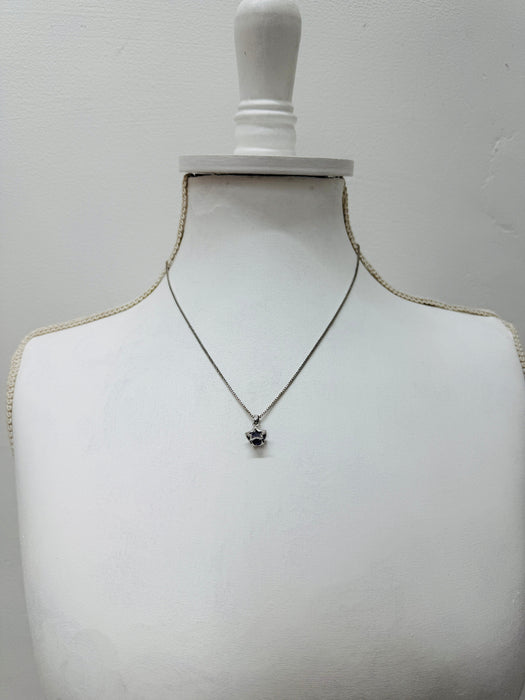 Necklace with a pendant on a mannequin bust against a plain background