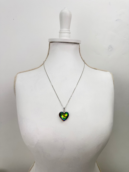 Heart-shaped pendant on a necklace displayed on a mannequin bust against a white background
