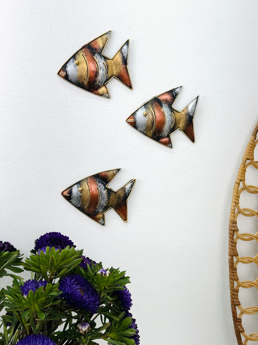 Copper zebra fish wall art displayed in a decorative grouping on a wall