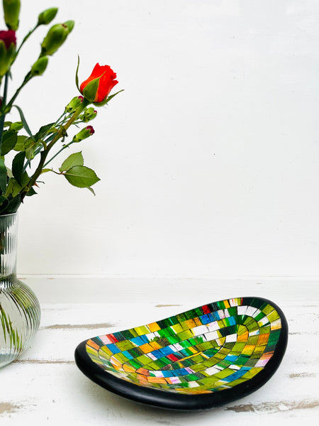 display view of mosaic oval bowl next to a vase of flowers