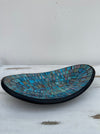 Side view of handmade small oval mosaic bowl in Miami design with light blue and aqua glass mosaic pieces.