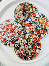 Group of Spectrum mosaic coasters displaying their vibrant and varied hand-painted glass patterns on a white background.