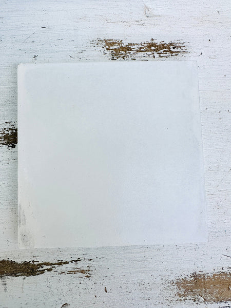 Back of the square brick mosaic coaster showing the smooth white MDF base on a light textured background.