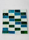 Square Turquoise Brick mosaic coaster featuring hand-painted glass rectangles in blue and green tones on an MDF base, photographed from above on a light surface.