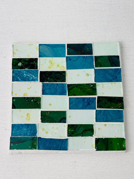 Square Turquoise Brick mosaic coaster featuring hand-painted glass rectangles in blue and green tones on an MDF base, photographed from above on a light surface.