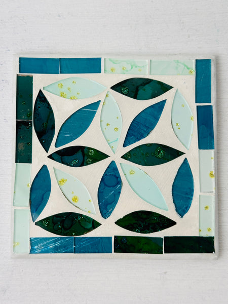 Square turquoise Peacock mosaic coaster with hand-painted glass pieces in blue and teal tones on an MDF base, photographed from above on a light surface.