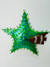 A hand-painted green metal starfish wall decoration with a unique textured finish.