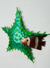 Side-angle view of green metal starfish showing painted texture