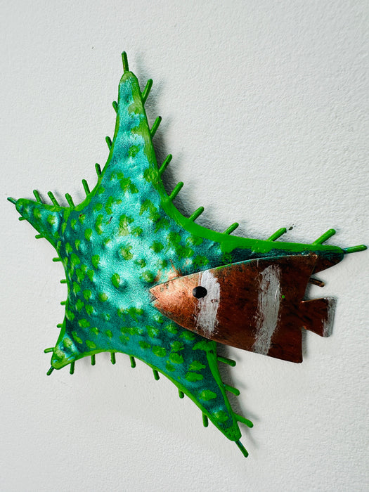 Side-angle view of green metal starfish showing painted texture