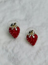 Red strawberry-shaped earrings with gold tops on a white background