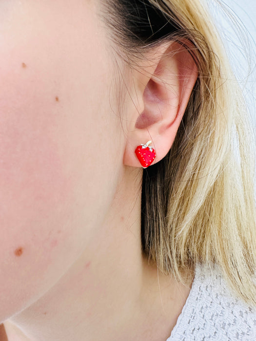 Red strawberry-shaped earrings with gold tops on a model