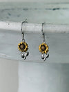 Sunflower-shaped dangle earrings on a white background.