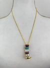 Gold tea cup necklace  on a mannequin bust.