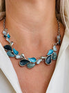 Teardrop enamel necklace in turquoise, grey, gunmetal and silver tones, displayed on a model.