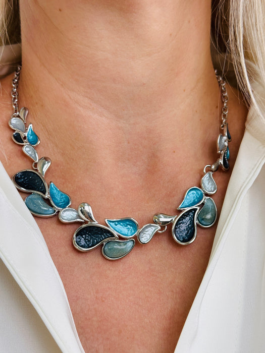 Teardrop enamel necklace in turquoise, grey, gunmetal and silver tones, displayed on a model.