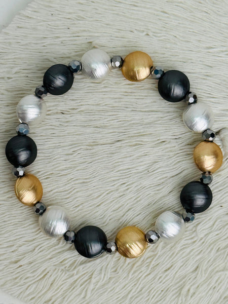 Tri-tone metallic beaded elastic bracelet in gold, silver and dark grey tones with grey spacer beads, displayed on a white background.