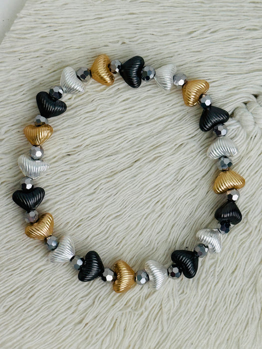 Tri-tone metallic beaded elastic bracelet in gold, silver and dark grey tones with grey spacer beads.