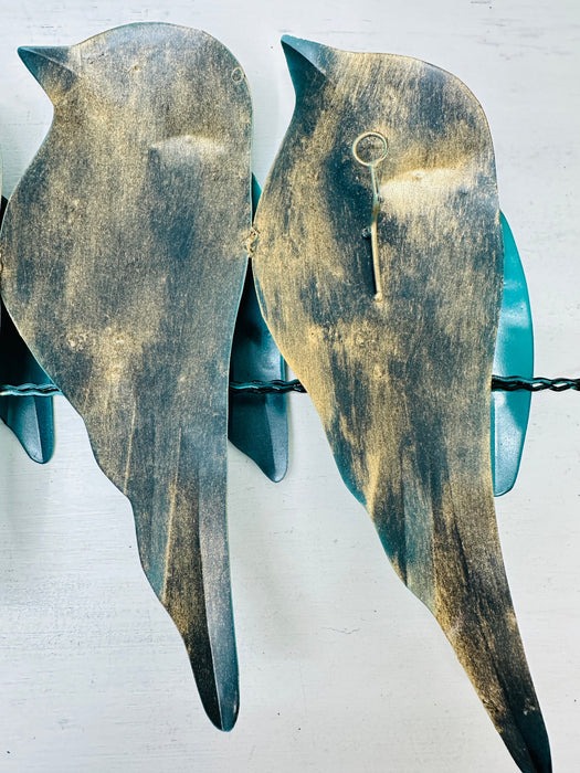 Back view of turquoise bird metal wall art showing hidden eyelet mounting rings