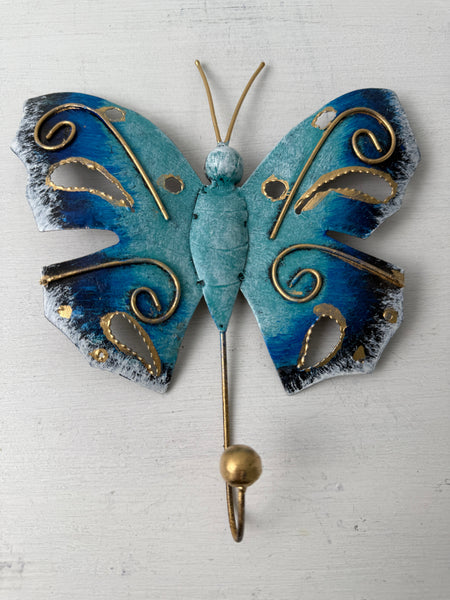 Hand-painted turquoise butterfly hook with gold detailing on white background.