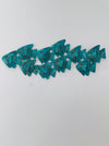 Turquoise crackle effect metal fish shoal wall sculpture displayed on a white wall