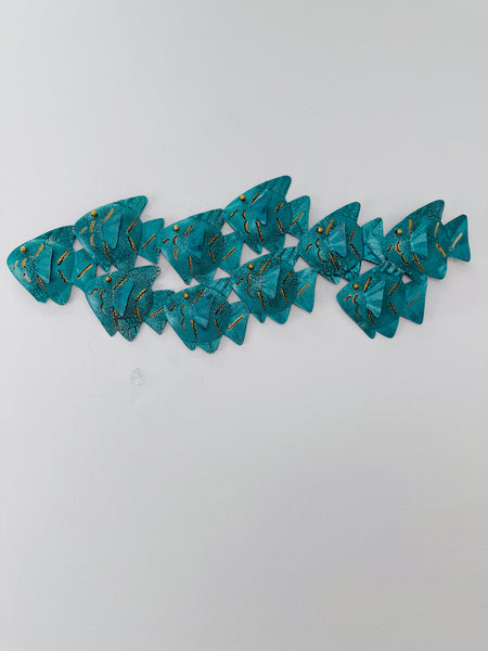 Turquoise crackle effect metal fish shoal wall sculpture displayed on a white wall