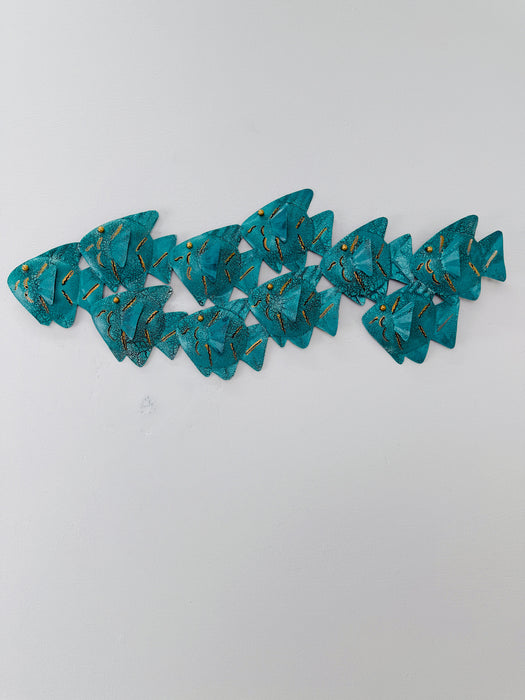 Turquoise crackle effect metal fish shoal wall sculpture displayed on a white wall