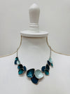 Turquoise enamel leaf statement necklace with silver-tone chain and layered leaf shaped accents, displayed on a mannequin.